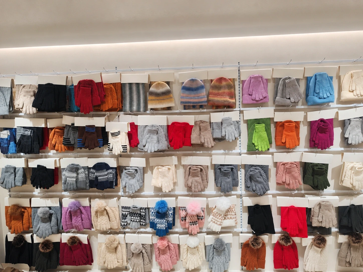Knitted gloves and coordinated accessories on a display wall