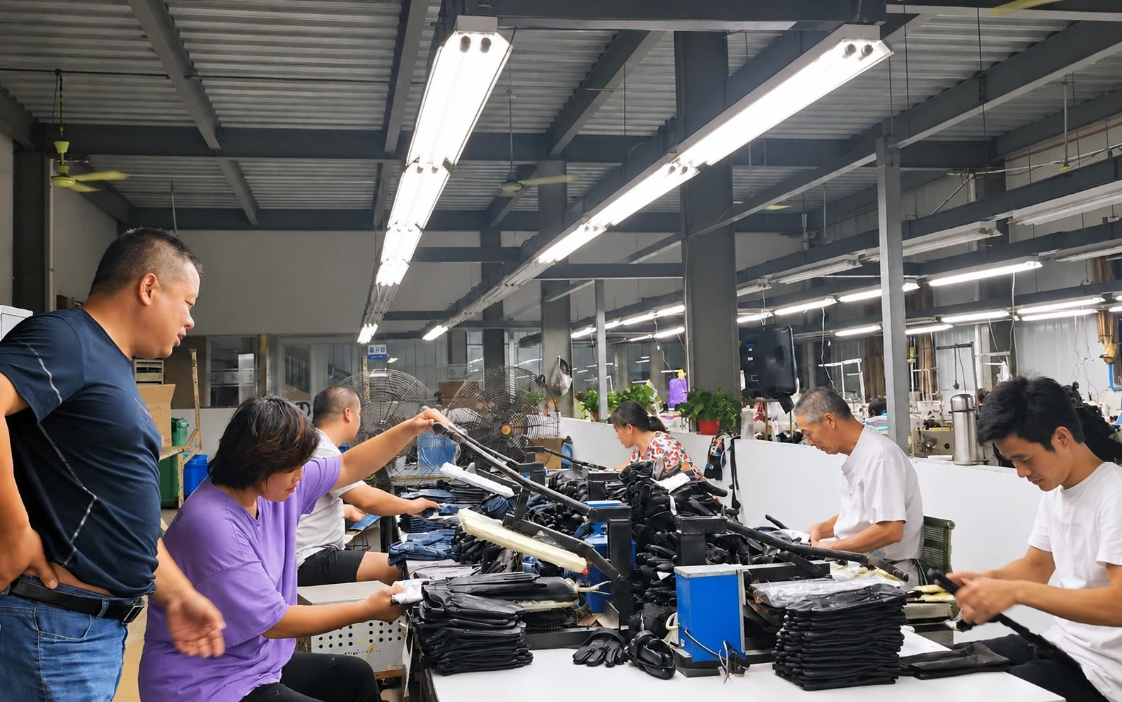 Workers handling leather gloves at a finishing workbench