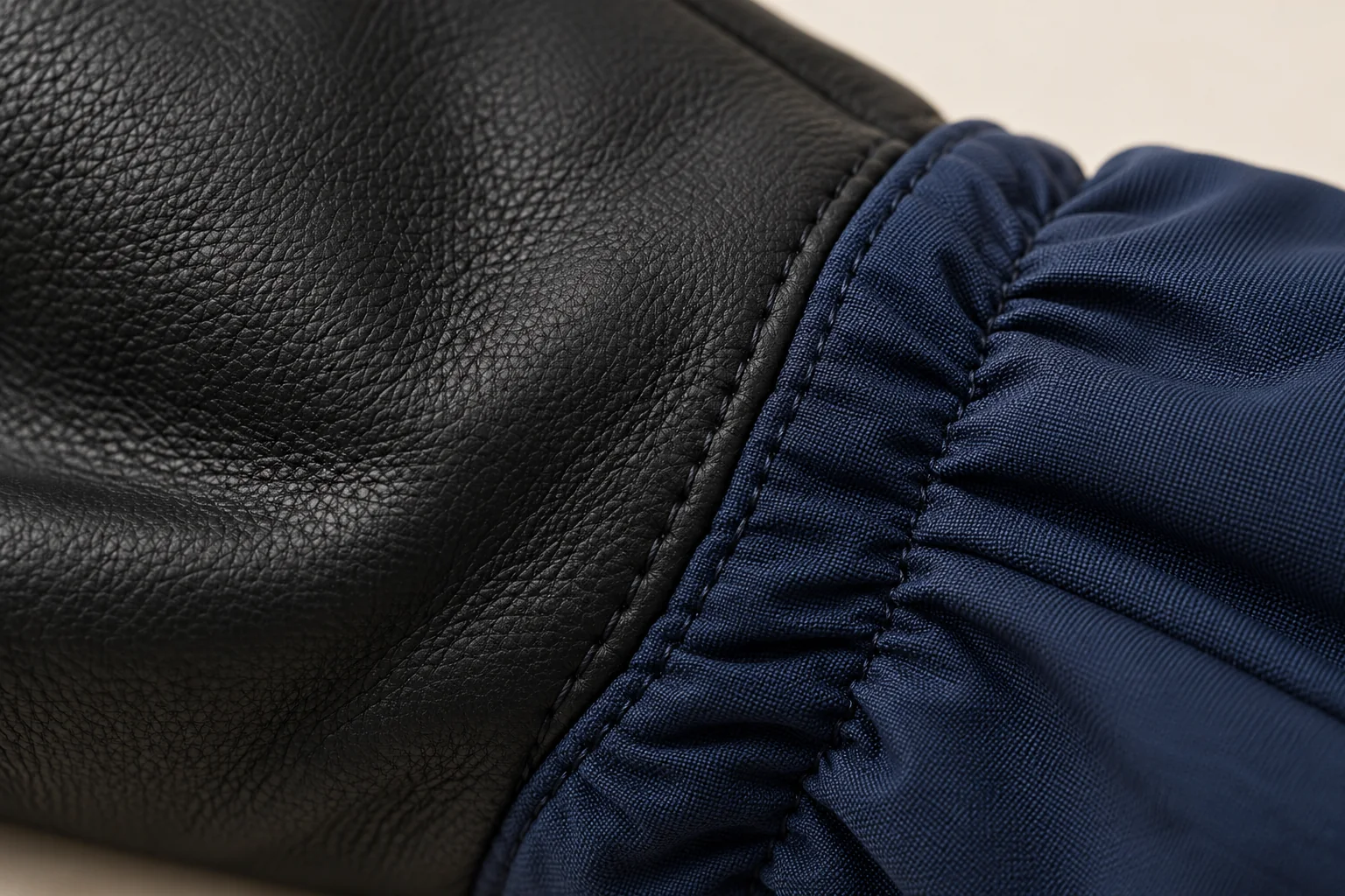 Navy winter glove: macro black palm meeting navy gathered wrist shell.