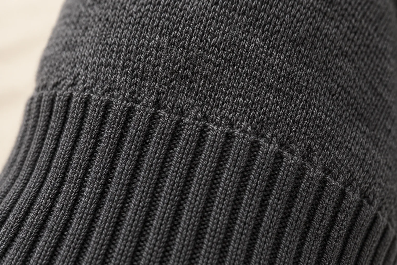 Charcoal knit glove: focus on a few centimeters of straight rib wrist meeting plain body knit.
