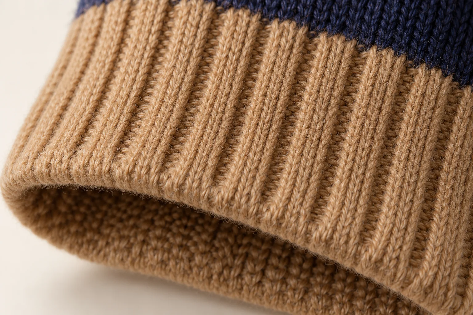 Two-tone knit glove: focus camel/tan rib cuff, close to its lower edge.